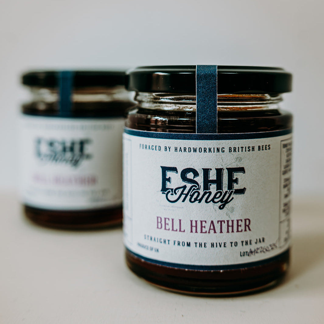 Two jars of Eshe Honey with labels on a light background