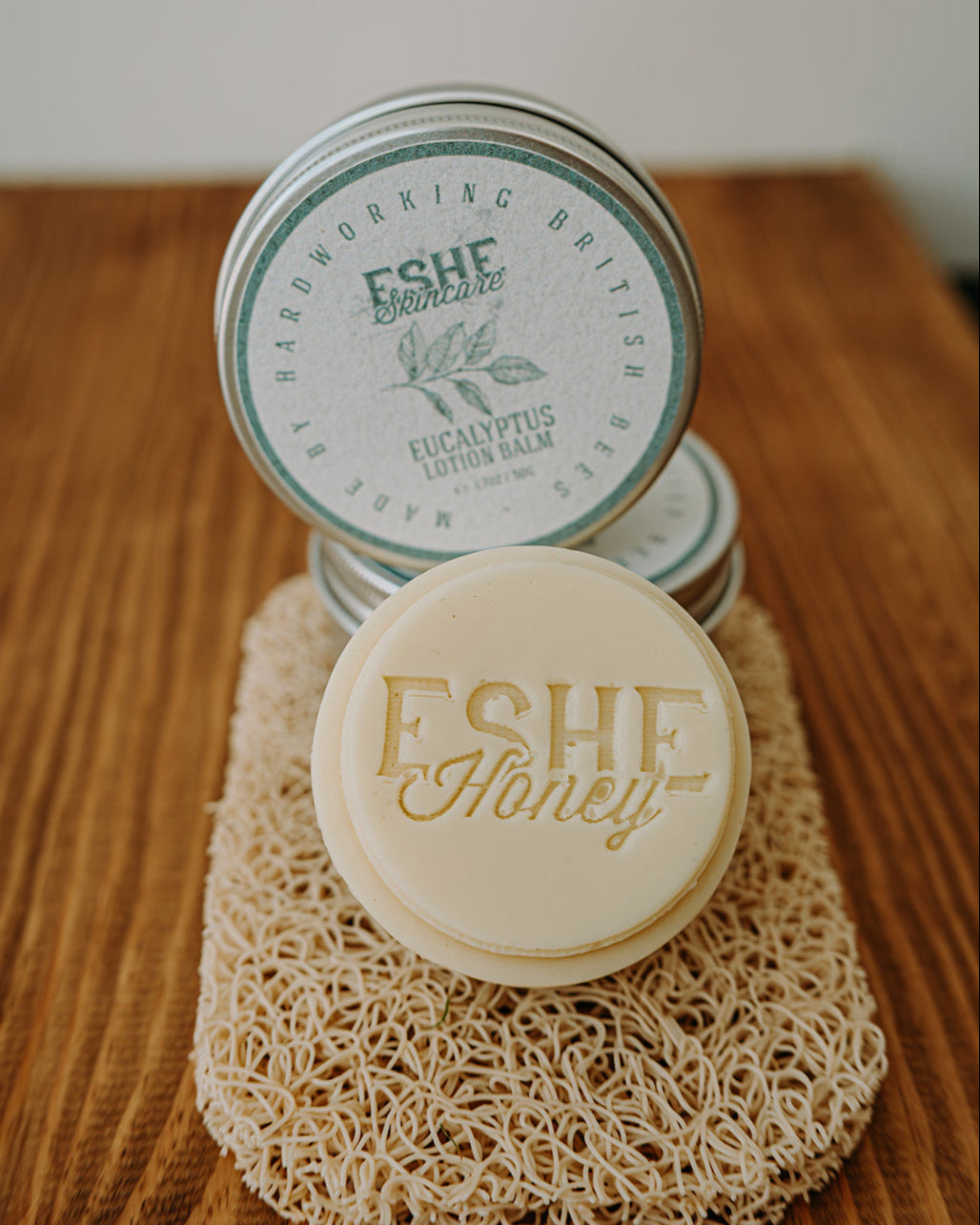Two containers of Eucalyptus Lotion Balm on a wooden surface