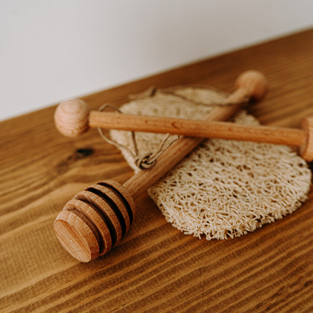Wooden honey dipper with a honeycomb on a wooden surface