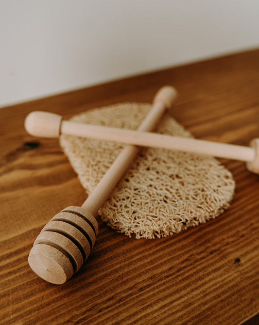Wooden honey dipper on a wooden surface