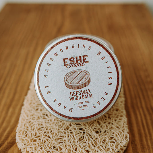Beeswax wood balm container with a mesh bag on a wooden surface